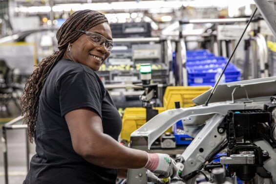 A woman working at the Toyota plant smiles at the camera.