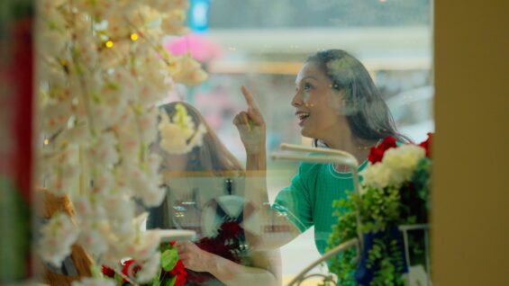 A woman looks into the window display of a shop.
